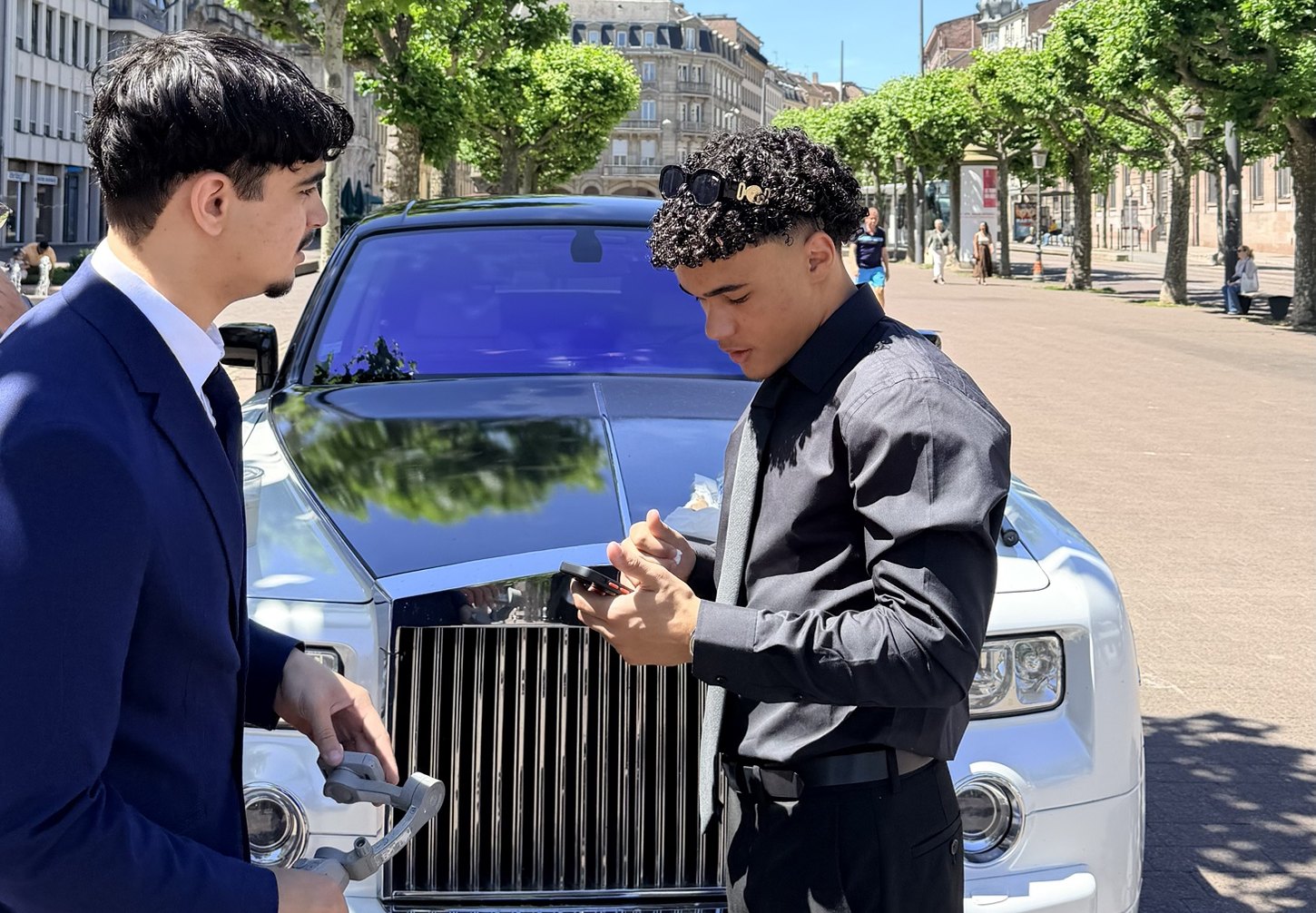 enaach prépare un tournage devant une voiture de luxe pour une agence de location de véhicules de prestige